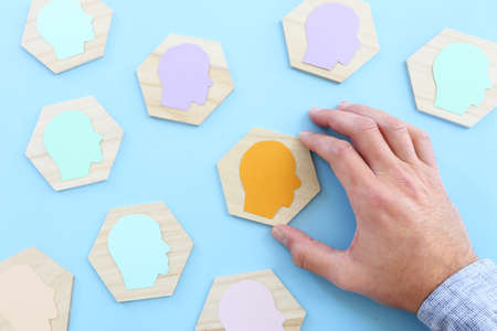 wooden blocks with people icon over blue background, building a strong team, human resources and management conceptの写真素材