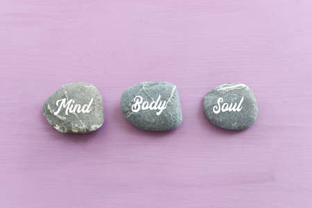 zen stones with the words Mind body soul. purple wooden backgroundの写真素材