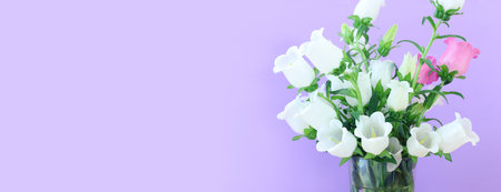 spring bouquet of purple, white and pink bell flowers over purple wooden backgroundの写真素材