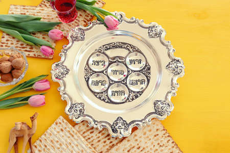 Pesah celebration concept (jewish Passover holiday). Traditional pesah plate text in hebrew: Passover, horseradish, celery, egg, bone, maror, sweet dates jamの写真素材