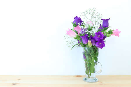 spring bouquet of white and pink bell flowers over wooden tableの写真素材