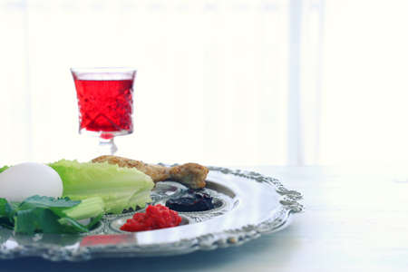 Passover background. Glass Wine cup and traditional plateの写真素材