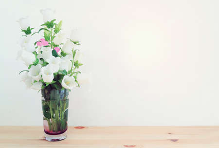 spring bouquet of white and pink bell flowers over wooden tableの写真素材