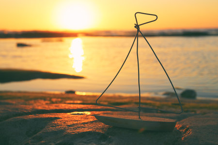 nautical concept with sail boat infront of sunset sea and beach landscapeの写真素材