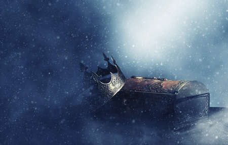 low key image of beautiful queen or king crown over gold treasure chest. vintage filtered. fantasy medieval periodの写真素材