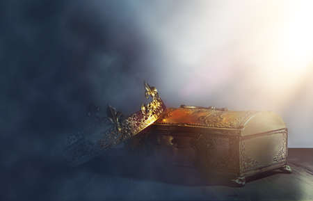 low key image of beautiful queen or king crown over gold treasure chest. vintage filtered. fantasy...