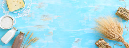 Top view photo of dairy products over blue wooden background. Symbols of jewish holiday - Shavuotの写真素材