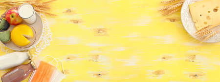 Top view photo of dairy products over yellow wooden background. Symbols of jewish holiday - Shavuot
