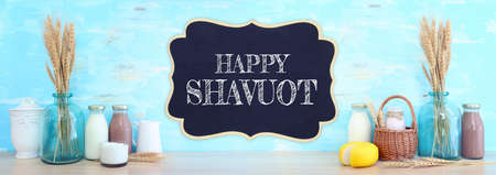 photo of dairy products over table and blue wooden background. Symbols of jewish holiday - Shavuotの写真素材