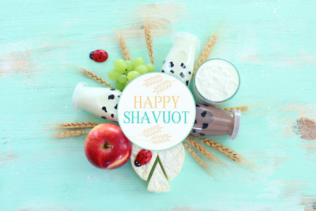 Top view photo of dairy products over blue wooden background. Symbols of jewish holiday - Shavuot