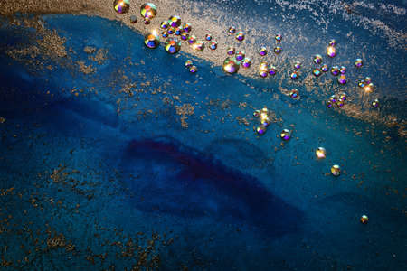 art photography of abstract fluid art painting with alcohol ink blue, aqua, gold colors and crystal rhinestonesの写真素材