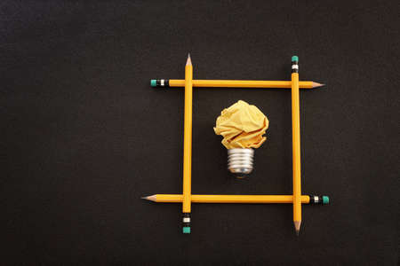 Education concept image. Creative idea and innovation. Crumpled paper as light bulb metaphor over black backgroundの写真素材