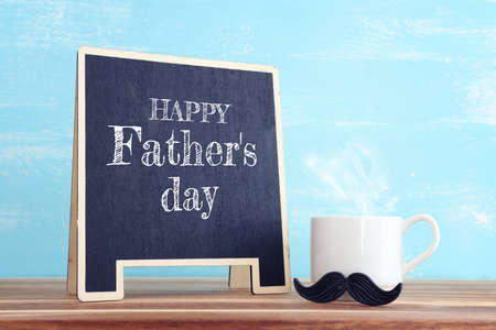 image of fathers day composition with hot cup of coffee over table and blue background