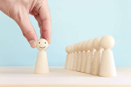 male hand holding people figure with happy face. concept of happiness emotion and satisfactionの写真素材