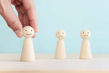 Concept image of satisfaction level. wooden people figures with emotions