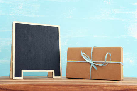 image of empty chalkboard over wooden table. Copy space for mock up and menuの写真素材