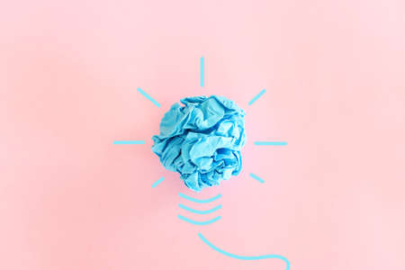 Education concept image. Creative idea and innovation. Crumpled paper as light bulb metaphor over pink backgroundの写真素材