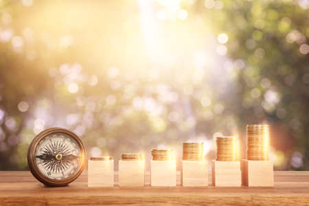 growing stack of coins on wooden table. financial success and management conceptの写真素材