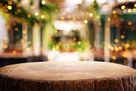 background Image of wooden table in front of abstract blurred restaurant lights