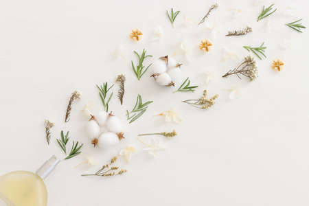 Top view of elegant perfume bottle with flowers over wooden white background. Cosmetics, fragrance and perfumery conceptの写真素材