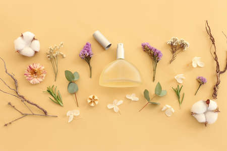Top view of elegant perfume bottle with flowers and oud over yellow background. Cosmetics, fragrance and perfumery conceptの写真素材
