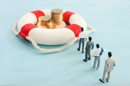Concept image of lifebuoy and stack of coins. idea and metaphor of financial support in times of crisisの写真素材