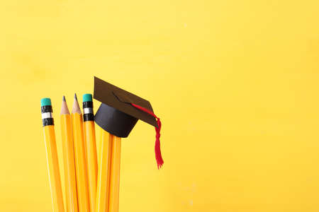 Image of education concept. Traditional graduation hat over pencilsの写真素材