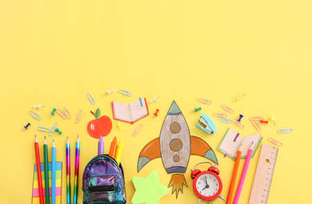 Back to school concept. Top view image of student stationery over pastel yellow background