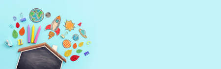 Back to school concept. Top view image of empty blackboard, space ship and student stationery over pastel blue backgroundの写真素材