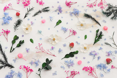 Top view image of pink, white, green and blue flowers composition over white wooden background .Flat layの写真素材
