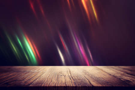 background Image of wooden table in front of abstract blurred lightsの写真素材