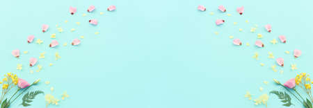 Top view image of pink, yellow and purple flowers composition over pastel blue background .Flat layの写真素材