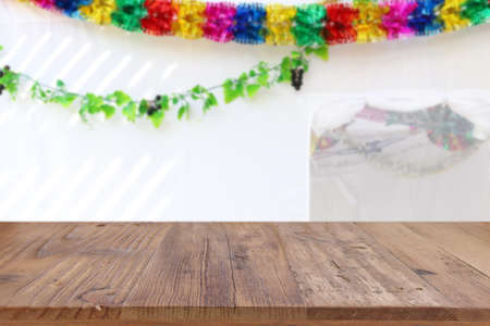 Jewish festival of Sukkot. Traditional succah (hut) with decorations. Empty wooden old table for product display and presentation.の写真素材