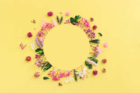 Top view image of pink, purple and green flowers composition over pastel yellow background .Flat lay