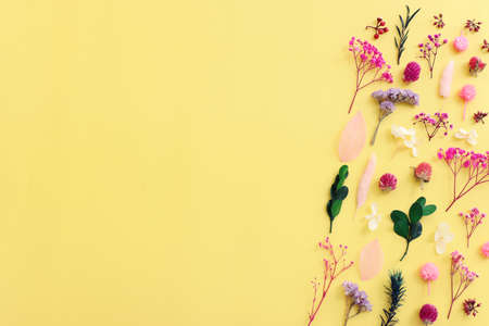 Top view image of pink, purple and green flowers composition over pastel yellow background .Flat layの写真素材