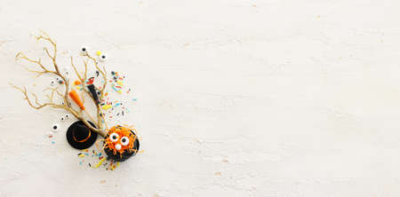 top view image of Halloween holoday. witcher cauldron and hat, broom, bare trees, treats over white wooden tableの写真素材