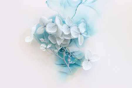 Creative image of pastel blue Hydrangea flowers on artistic ink background. Top view with copy space