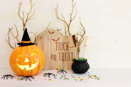 holidays image of Halloween. spiders, pumpkin and wooden board frame with text