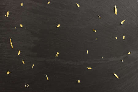 Black slate and golden confetti backgroundの写真素材