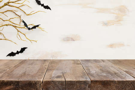 Halloween holiday concept. Empty rustic table in front of bare trees and bats background. Ready for product display montageの写真素材