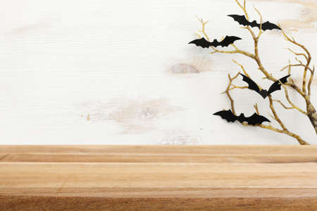 Halloween holiday concept. Empty rustic table in front of bare trees and bats background. Ready for product display montageの写真素材