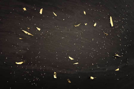 Black slate and golden confetti backgroundの写真素材