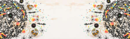 top view image of Halloween holoday. witcher broom, treats, spiders and bats over white wooden tableの写真素材