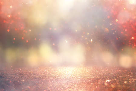 blurred abstract photo of light burst among trees and glitter golden bokeh lights