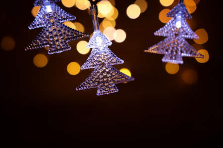 Christmas warm gold garland lights over dark background with glitter overlay