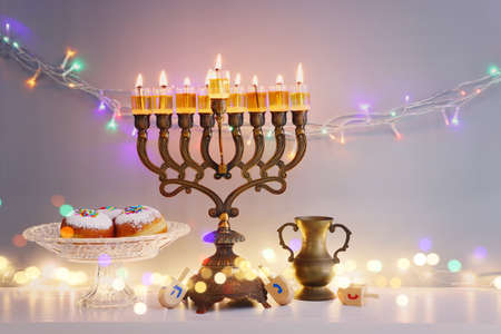 Religion image of jewish holiday Hanukkah background with menorah (traditional candelabra), doughnut...