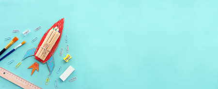 education. Back to school concept. rocket cut from paper and painted over blue wooden background....