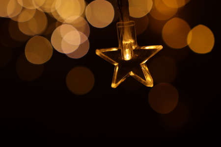 Christmas warm gold garland lights over dark background with glitter overlay
