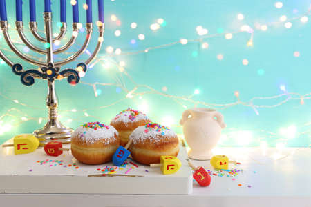 Religion image of jewish holiday Hanukkah background with menorah (traditional candelabra), doughnut and candlesの写真素材