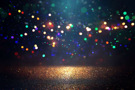 background of abstract glitter lights. gold, blue and black. de focused